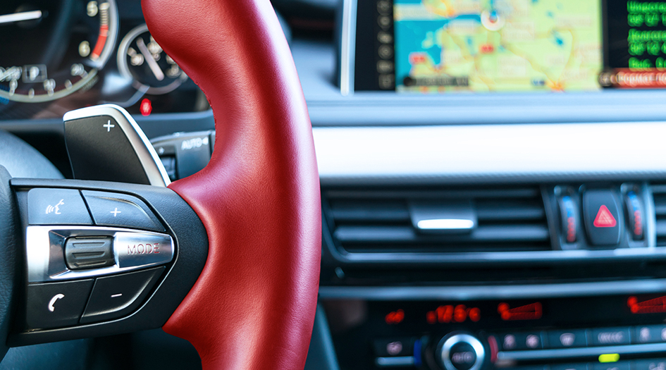 A close up on the bluetooth phone controls on a car steering wheel shows you how technology can help you avoid distracted driving