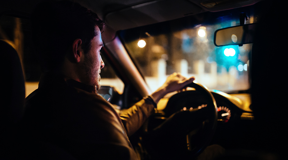 Here's 7 tips for safer night driving, as shown by a man driving in the dark