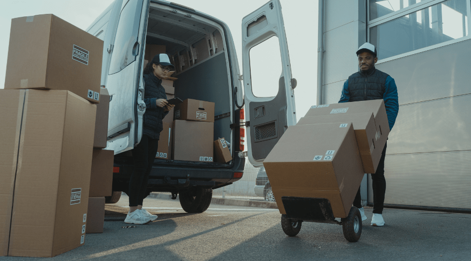 Two people load boxes into a white van, showing one way to protect your small business against cargo and heavy equipment theft.