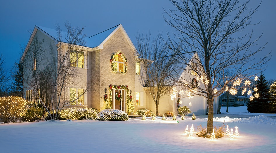 Une maison recouverte de neige et de décorations vous rappelle de prendre des mesures pour prévenir les vols par effraction en votre absence pendant les Fêtes.