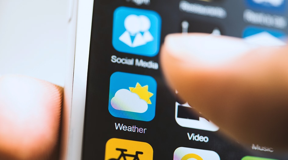 Preparing for a hurricane is important to protecting family and assets, as shown by a close-up of a finger pressing the weather app on a smartphone