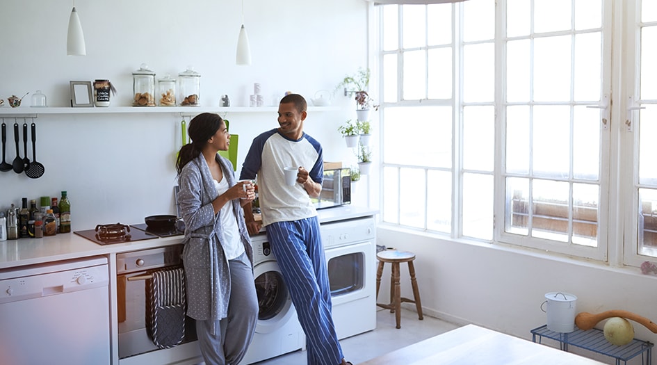 Here's a renter's guide to tenant insurance, as shown by a man and woman drinking coffee in their apartment kitchen