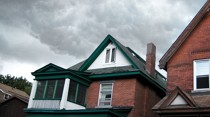 Everyone should know what to do before, during, and after a tornado, as shown by dark clouds overtop the roof of a house