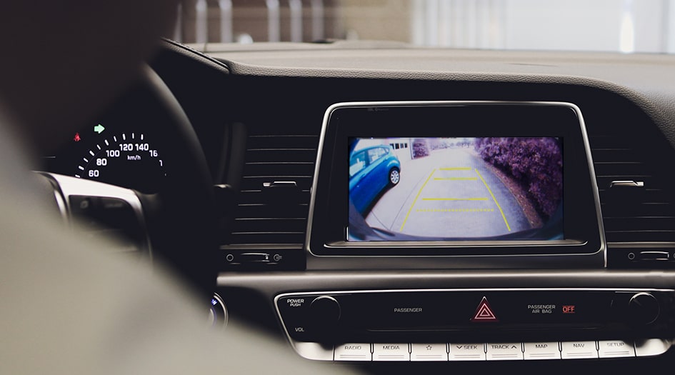 A close up of a rear-view camera screen in a car shows you how rear-view cameras work to prevent back-up collisions