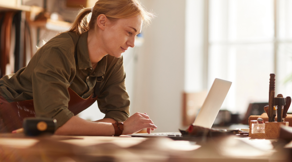 A woman checks her laptop for security concerns, showing one way to protect your small business from cyber-attacks