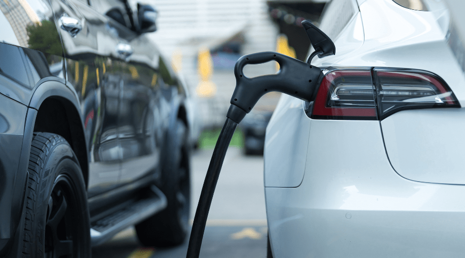 A charger plugged into a white electric vehicle shows how you can safely charge your EV.