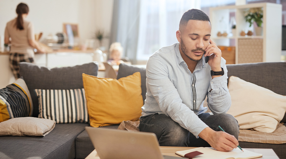 Un homme discute au téléphone mobile, informant sa compagnie d’assurance de quelques modifications qu’elle doit connaître.