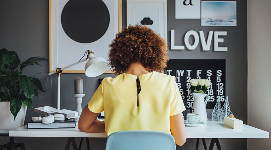 Protecting your home-based business with the right insurance is important, as shown by this woman working at a desk in her home