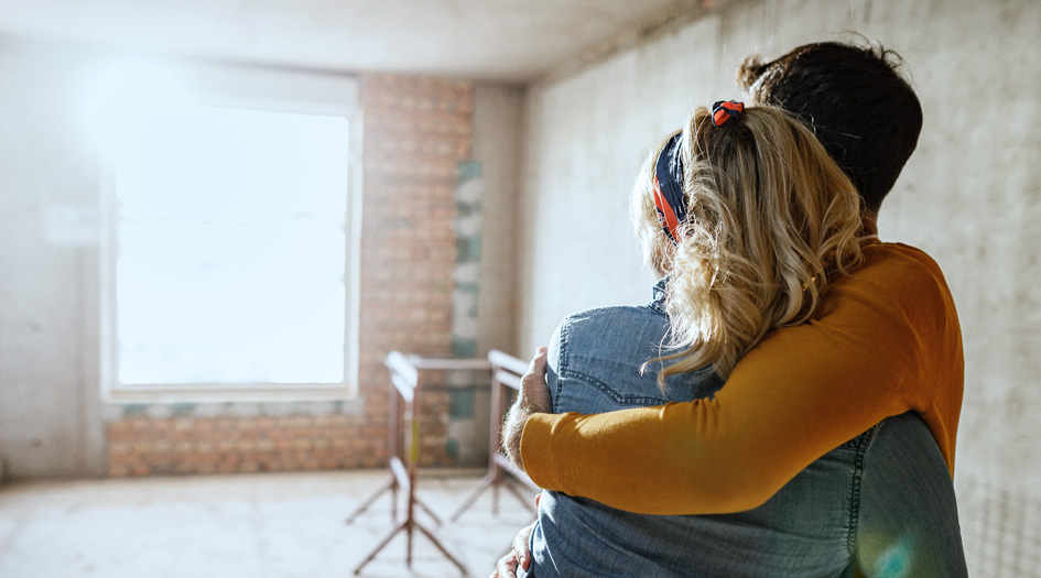 A couple stands in their home as it gets renovated, which was possible after applying for natural disaster relief.