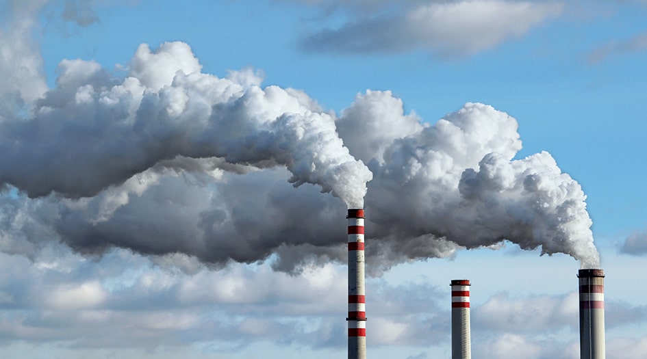 Three smokestacks emit white clouds, illustrating how the Canadian carbon tax works and how you can save money