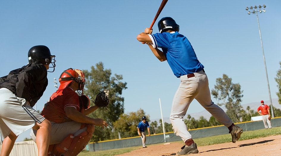 Third-party liability insurance can tag along with you anywhere, even at a baseball game, as shown by three individuals playing baseball