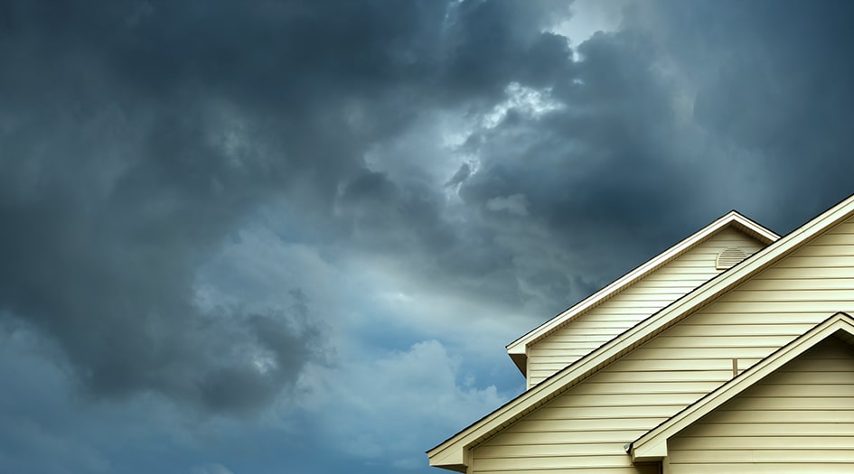 Dark clouds sit over a roof, showing you how to prepare for more severe weather