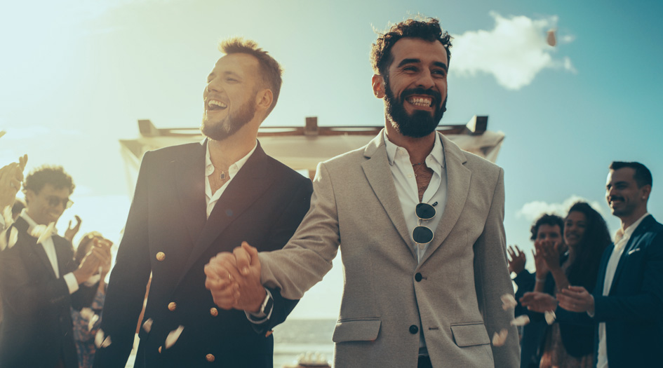 Here are some insurance tips for newlyweds, as shown by two men holding hands as they walk down the aisle