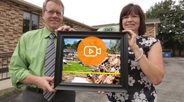 Economical customers hold up a photograph of damage from the Goderich tornado