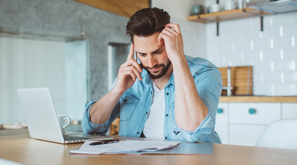 A man looks concerned while talking on his cellphone, as he wonders if he must pay his deductible if he's not at fault