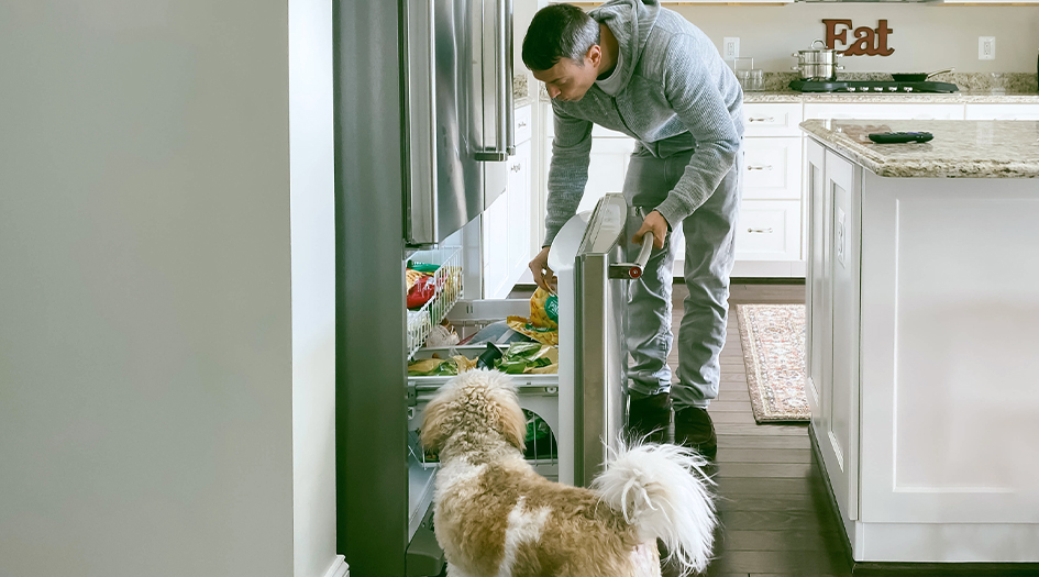 Here’s how home insurance covers spoiled food, as shown by a man looking in his freezer