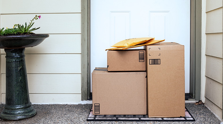 Here are 7 tips to avoid package theft, as shown by a stack of packages sitting on a porch