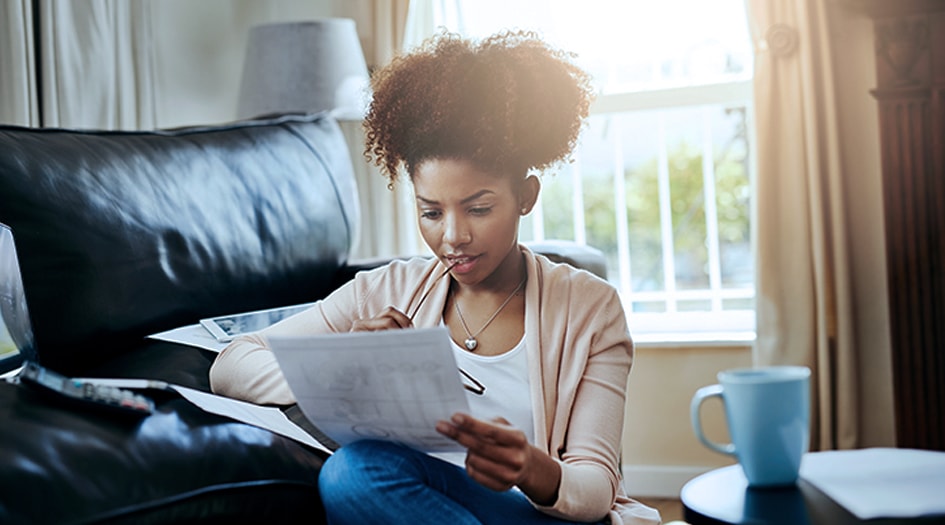 A woman concentrates while examining some papers, showing you what you may need to change when renewing your insurance