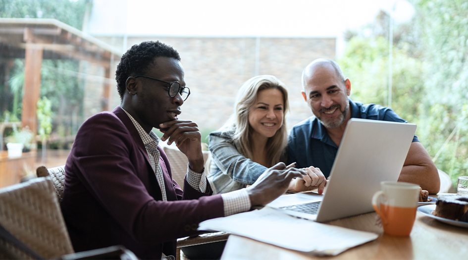 A couple reviews the difference between replacement cost and actual cash value on a broker's laptop