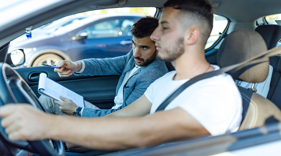 Two men sit in a car as the passenger instructs the driver to make a turn, showing a top tip for new drivers in Canada