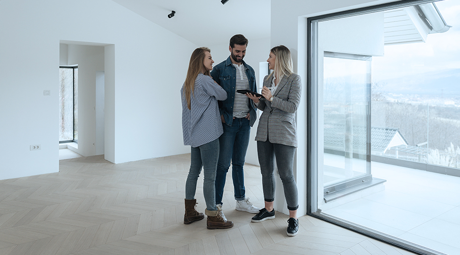 A couple chats with a real estate agent in an empty apartment, asking the questions you need to ask before renting an apartment