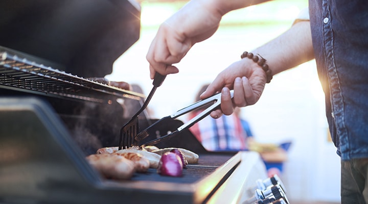 If you don't have AC during the summer, there are a few ways to beat the heat, like grilling dinner, as shown by a man grilling chicken on a BBQ