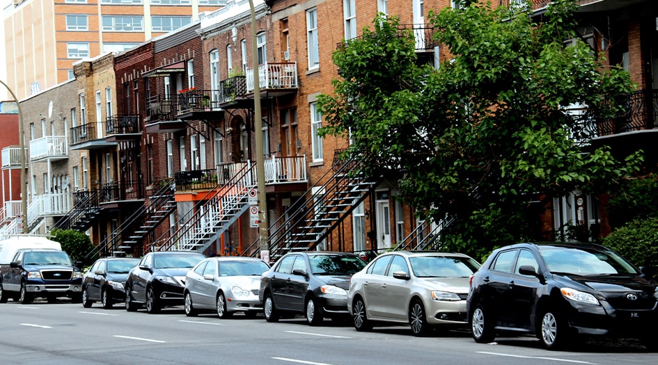 A city street is lined with parked cars, showing the most stolen vehicles of 2019 in Canada