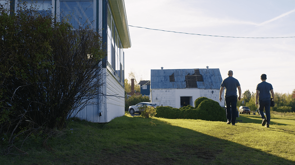 Two people surveying building damage