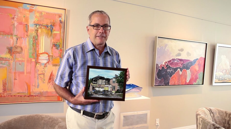An Economical customer holds a picture of his damaged home