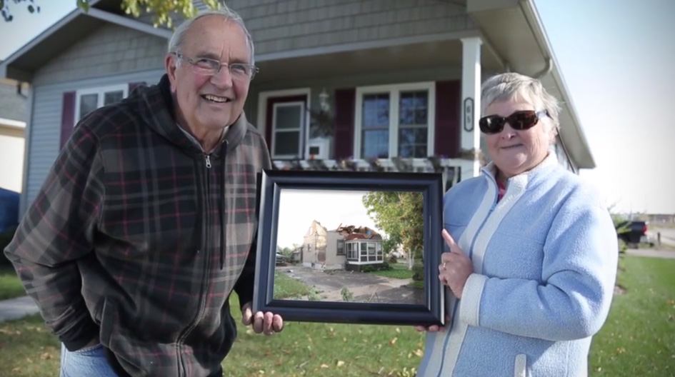 Economical customers hold a picture of their tornado ravaged home