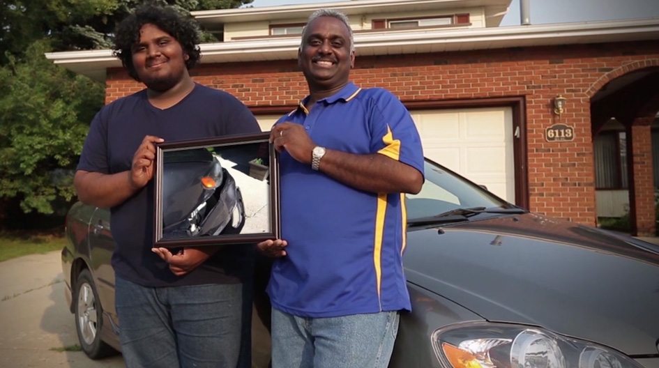 Economical customers, Father & son holding a picture of their damaged car