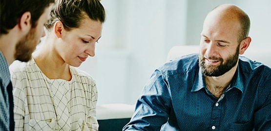Three employees meet in an office