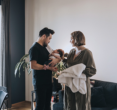 A young family standing in their living room