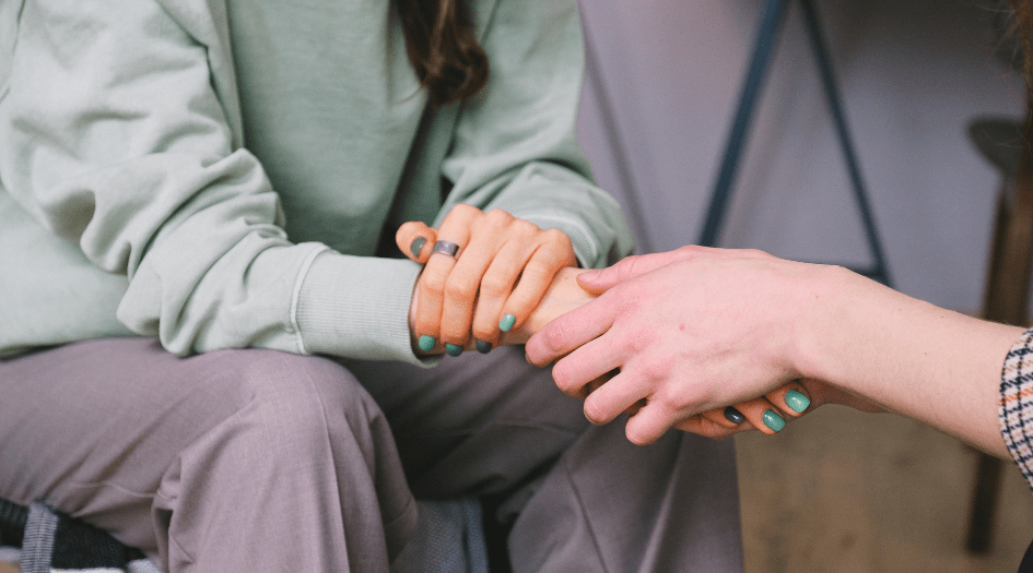 Deux personnes se tenant la main, montrant une façon de prioriser votre santé mentale après une catastrophe naturelle.