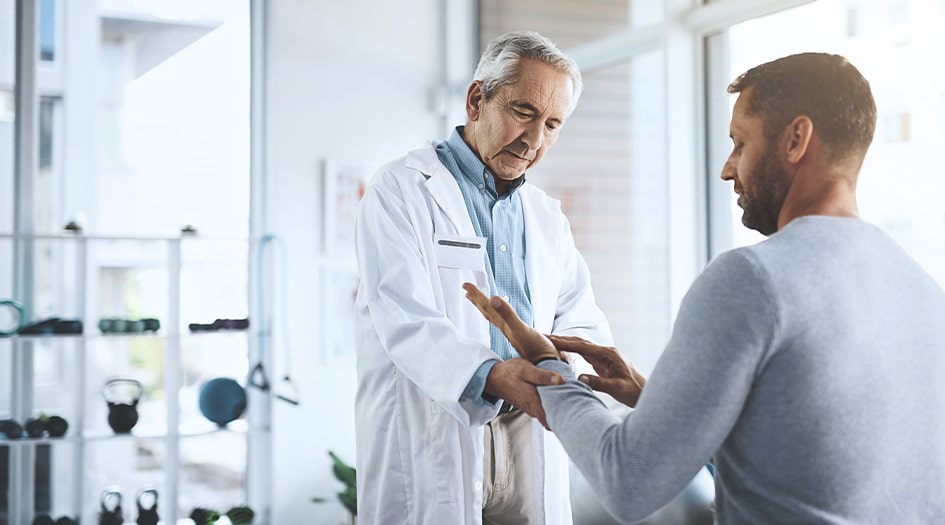 Voici ce qui est couvert par les indemnités d’accident, illustré par un homme faisant soigner sa main par un médecin.