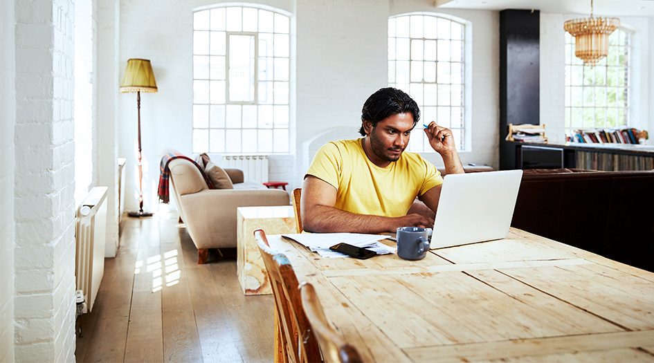 A man shows you how to stay on track while working from home as he sits at the kitchen table on his laptop