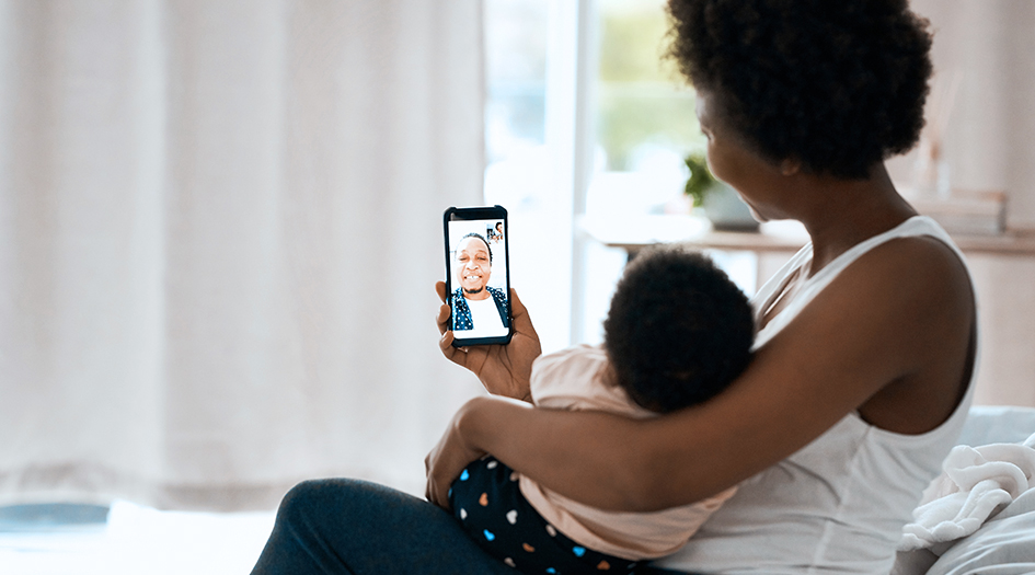 Voici ce que vous devez savoir sur l’assurance de votre téléphone mobile, illustré par une femme et son bébé en appel vidéo.